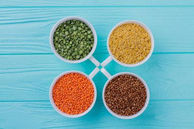 Kadehler mavi ahşap üzerinde farklı tanelerle dolu..