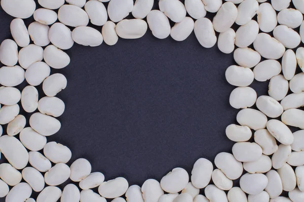 濃い青の背景に白い豆から作られたフレーム. — ストック写真