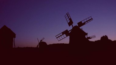 Kırsalda gün batımında yel değirmenleri.