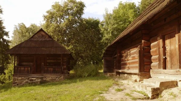 Dwie chatki na ceglanym fundamencie otoczone są drzewami.. — Zdjęcie stockowe