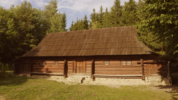 Long log house περιβάλλεται από δέντρα. — Φωτογραφία Αρχείου