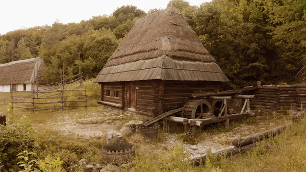 Drewniany dom wiejski z dużym dachem i młynem historycznym. — Zdjęcie stockowe