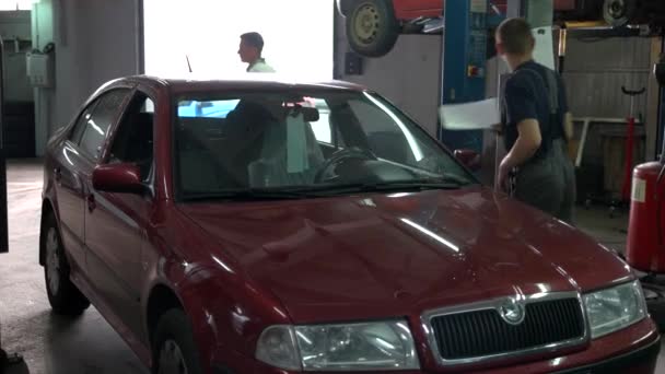 Rotes Auto in einer Autowerkstatt. — Stockvideo