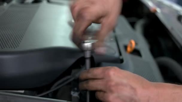 Mekaniker skruvar loss bilens motordetalj. — Stockvideo