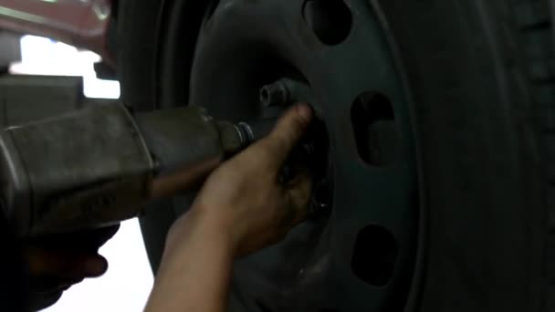 Mecánico de coche quitando tuercas de rueda con pistola . — Vídeos de Stock