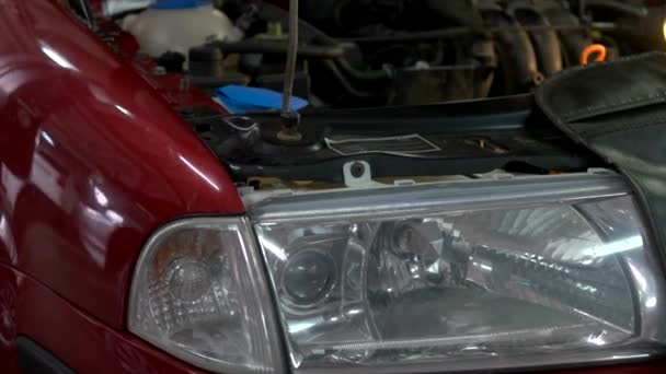 Close up car headlight with opened hood. — Stock Video