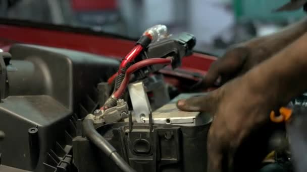 Auto mecânico instalando bateria acumulador . — Vídeo de Stock