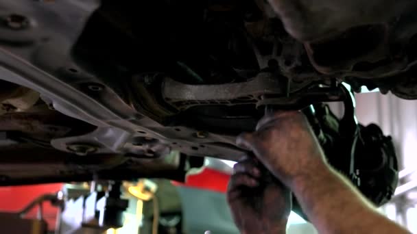 Mecánico de coche está instalando un perno por manos grasosas . — Vídeos de Stock