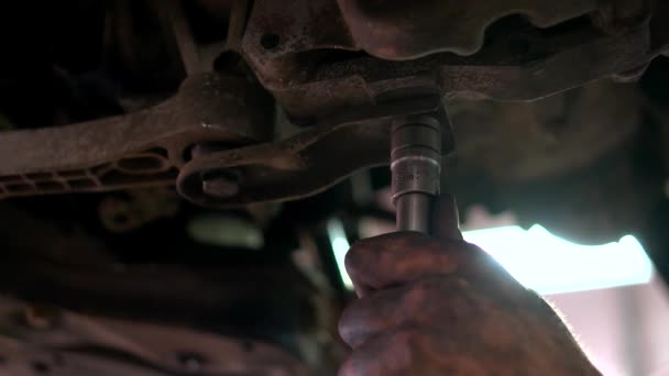 Mecánico se atornilla perno en la parte inferior de los coches . — Vídeo de stock