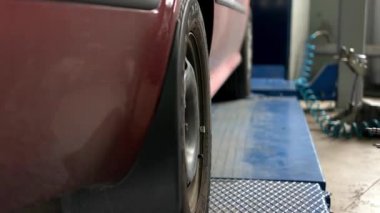 Araba tamircisi tekerlek kapağını çıkarıyor ve Camber Caster göstergesini ayarlıyor..