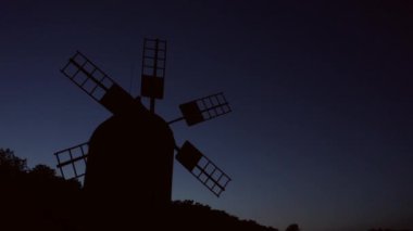 Hala hareketsiz yel değirmeni silueti.