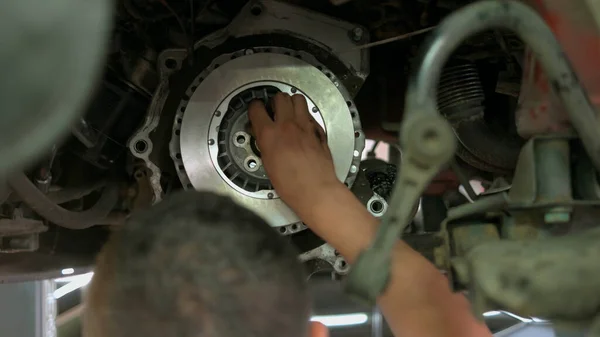 Mécanicien automobile installe des boulons dans embrayage de voiture en métal . — Photo