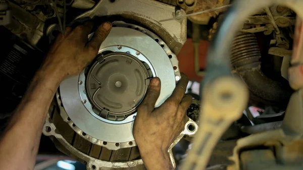 Hands of a mechanic adjustic metal car clutch. — Stock Photo, Image