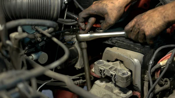 Fechar as mãos mecânicas parafusar algo em um mecanismo de motor de carro . — Fotografia de Stock