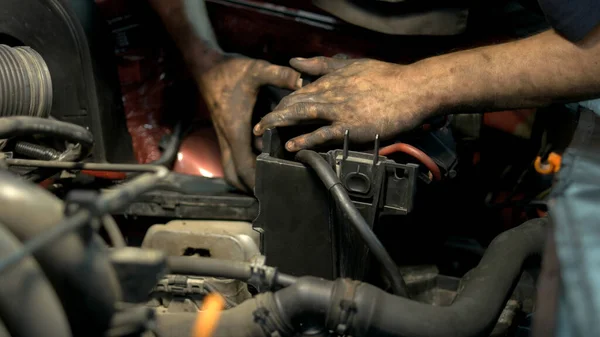 Mechanik se špinavýma rukama odinstalování a upevnění automobilového motoru detaily. — Stock fotografie