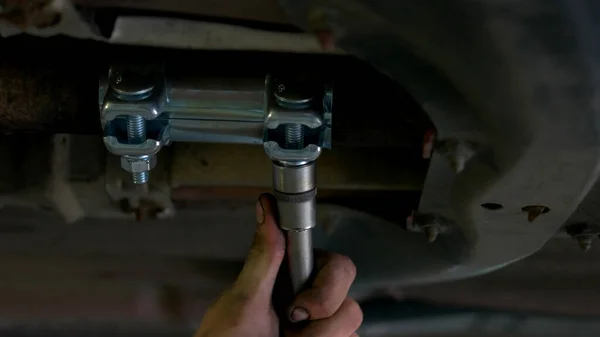 Mécanicien automobile serrant les écrous à l'aide d'une clé . — Photo