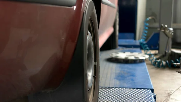 Mécanicien de voiture est de retirer le capuchon de roue et réglage jauge de roulette cambre . — Photo