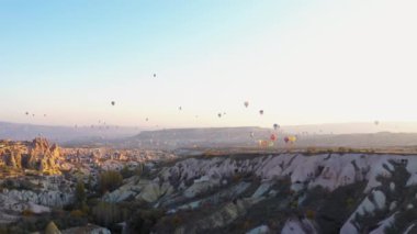 Sıcak hava balonları dağların üzerinde uçuyor..
