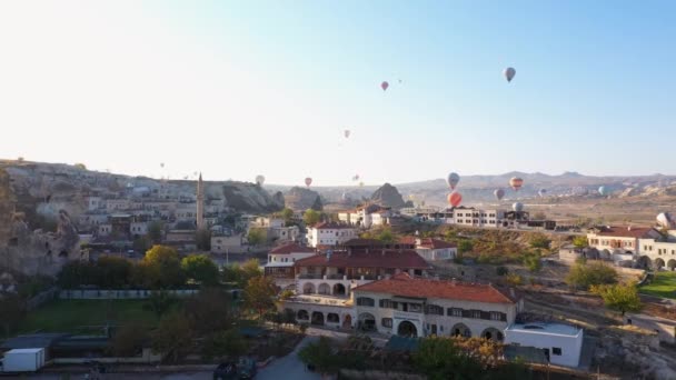 Globos volando sobre la pequeña ciudad de Goreme en Capadocia. — Vídeos de Stock