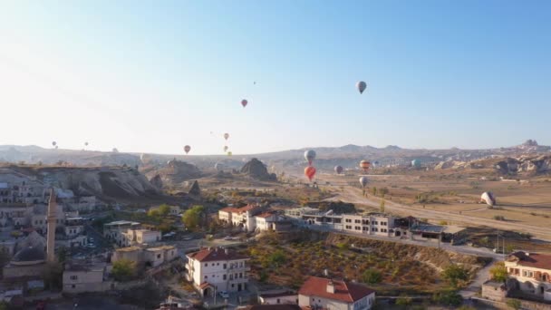 Hőlégballonok repülnek Goreme falu felett Cappadociában, Törökországban. — Stock videók