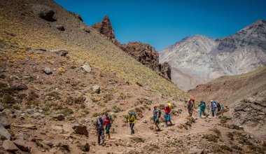 Bir grup turist bir dağ vadisinde yürüyor.
