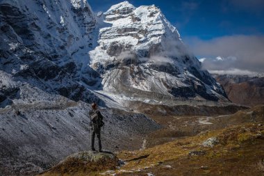 Ağırlık vadisinde bir turist bir dağ sırasına bakar.