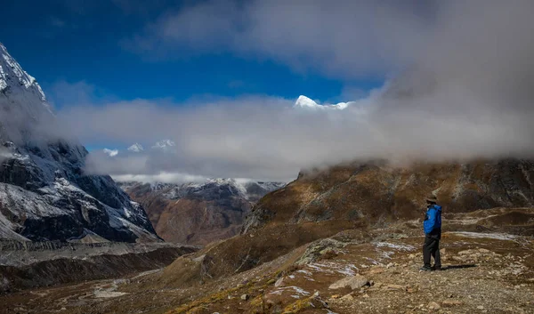 Een toerist in een gewichtsvallei kijkt naar een bergketen — Stockfoto