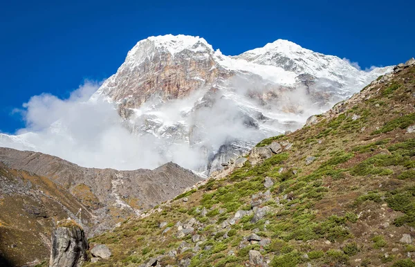Mooie berg met besneeuwde opbrengsten. berg in de wolken — Stockfoto