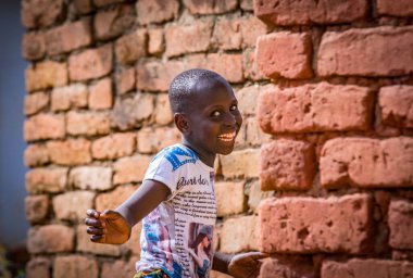 Küçük çocuk Tanzanya sokaklarında turistlere gülümsüyor