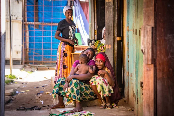 Tanzanya sokaklarında yaşayan Afrikalı bir aile. Parlak giysiler.