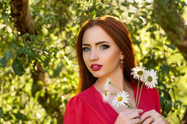 Sensual red haired young woman with fresh skin and beaty makeup holding bright bouquet of daisies outdoors — Stock Photo, Image