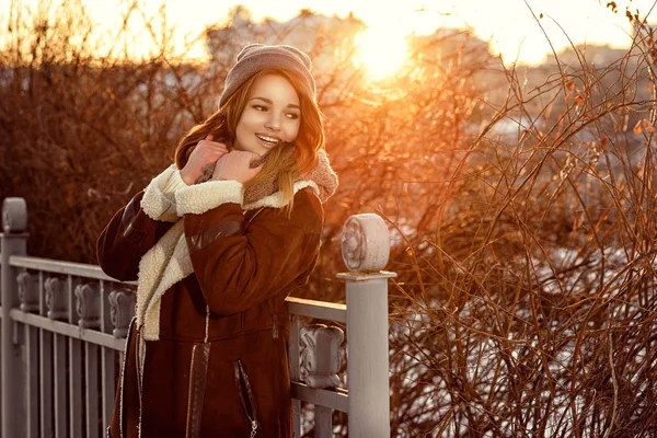 幸せな女の子でコートを着て街を歩いて寒い冬の夜に夕日 — ストック写真