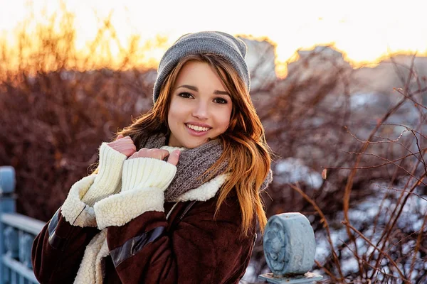 Gros portrait hivernal d'une jeune femme joyeuse au coucher du soleil. Brillant soleil — Photo