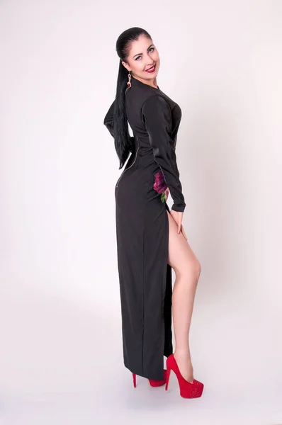 Красива жінка модель позує в елегантній чорній сукні в студії — стокове фото