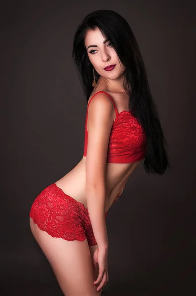 Verleidelijke vrouw in rode lingerie dragen op donkere backround — Stockfoto