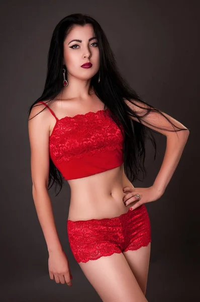 Förförisk kvinna som bär röda underkläder på mörka bakrund — Stockfoto
