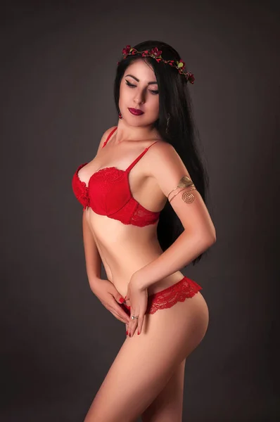 Mulher sedutora vestindo lingerie vermelha no fundo escuro — Fotografia de Stock