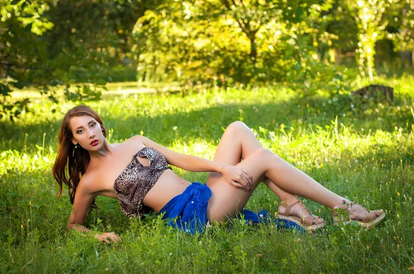 Attractive leggy woman lying on grass — Stock Photo, Image