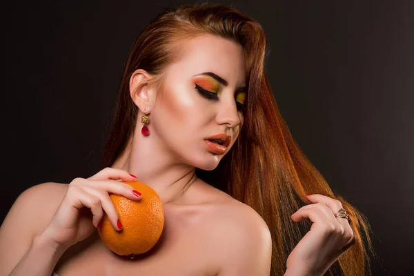 Aantrekkelijke jonge vrouw met oranje met schoonheid make-up — Stockfoto