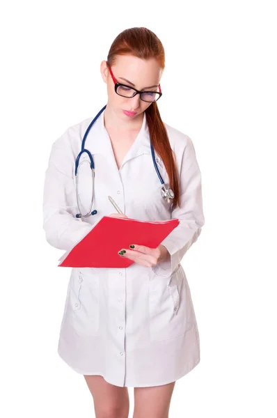 Schöne junge Ärztin in medizinischem Gewand, die eine Krankenakte hält. Krankenschwester macht Einträge in Krankenakte — Stockfoto