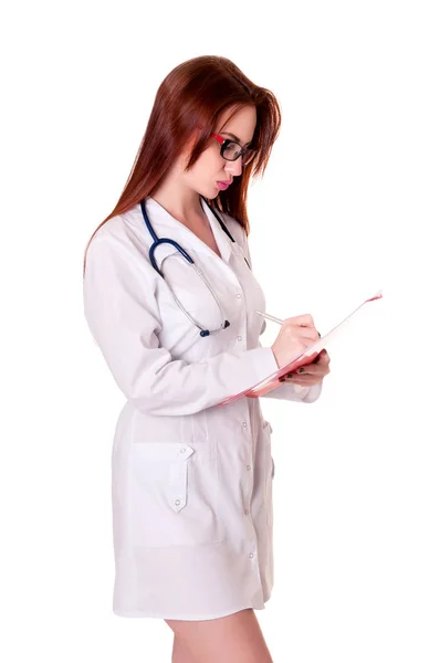 Attraktive junge Krankenschwester in Uniform. hält einen Ordner und schreibt Krankengeschichte. isoliert auf weißem Hintergrund — Stockfoto