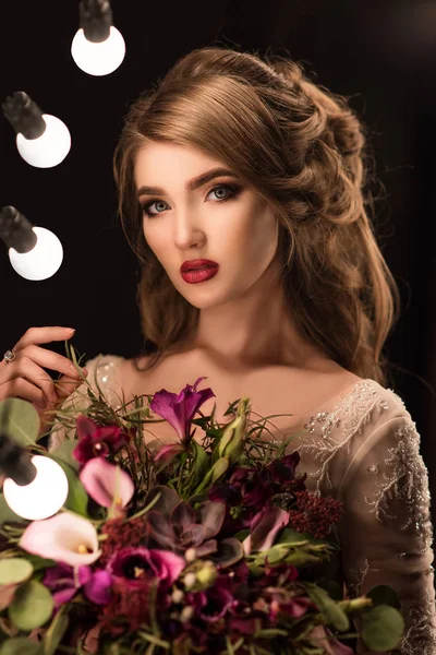 Güzellik modeli kadınla güzel makyaj ve kıvırcık saç stili koyu arka plan üzerinde. Düğün kutlama. Glamour gelinle mükemmel makyaj ve saç modeli