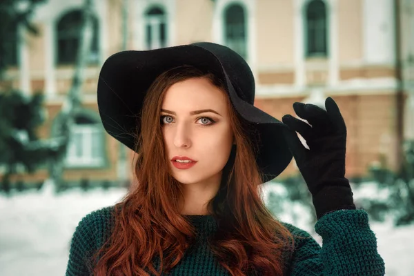 Closeup portret van een jong mooi meisje in een warme trui, een zwarte pet. Jonge vrouw winter portret — Stockfoto