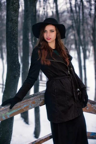 Giovane donna che indossa eleganti vestiti invernali passeggiando nel parco — Foto Stock