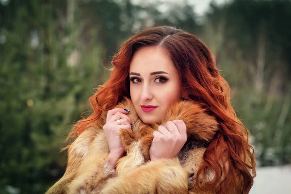 Atractiva joven con el pelo rojo. Primer retrato de invierno. Peinado rizado y maquillaje —  Fotos de Stock