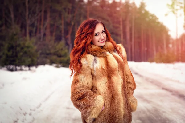 Vonzó fiatal nő, gyömbér haj, séta a téli erdő. Télen szabadtéri csinos nő. Téli ruhában. — Stock Fotó