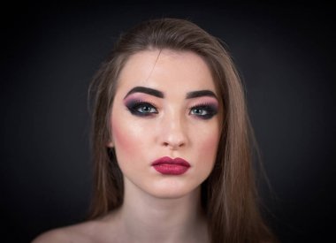 Kırmızı ruj ve uzun saçları koyu arka plan üzerinde poz ile ifade makyaj kadın modeli. Portre sanat portre
