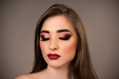 Kırmızı ruj ve uzun saçları koyu arka plan üzerinde poz ile ifade makyaj kadın modeli. Portre sanat portre