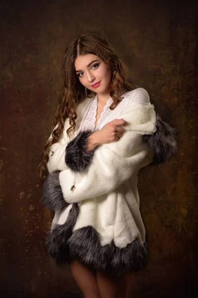 Superbe jeune femme posant dans un manteau de fourrure et un body luxueux. Mode, beauté. Plan studio . — Photo