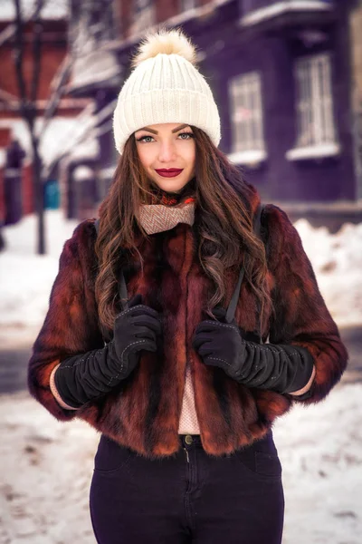 Happy winter time in big city of charming young woman walking on street in coat